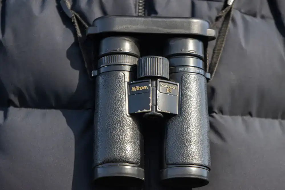 Premium birding binoculars resting on a field guide