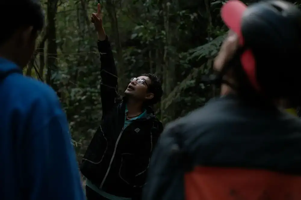 A guide pointing out a bird to a guest